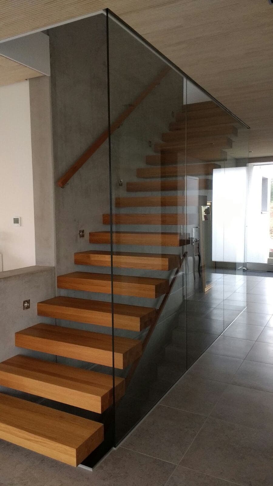 Freitragende Treppe aus Eichenstufen mit Stahlträger und Glaswand