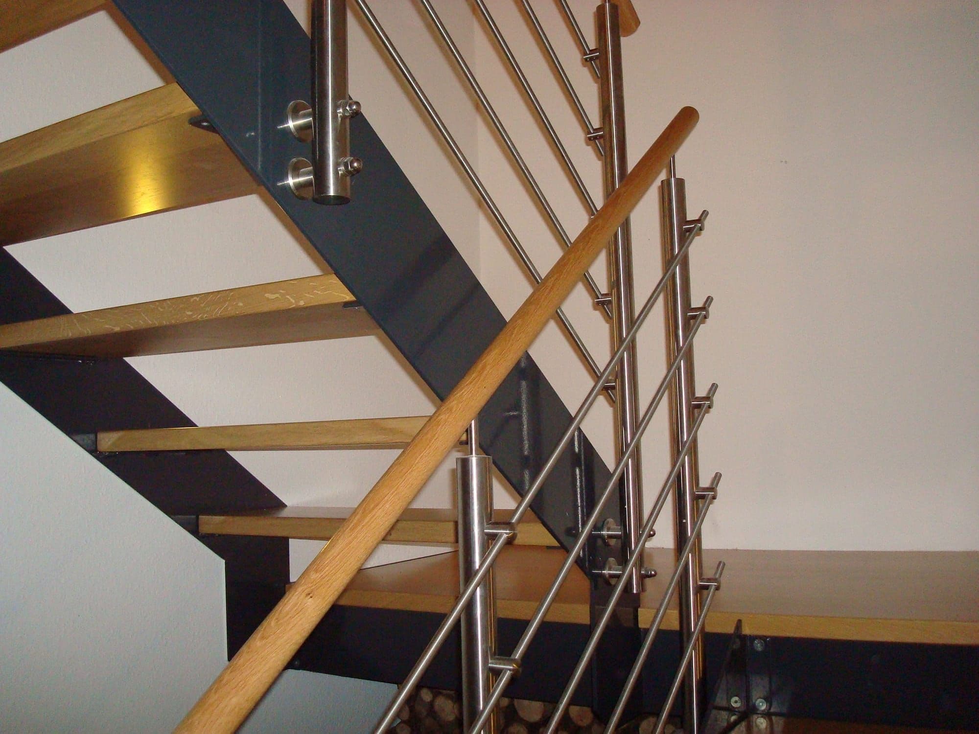 Treppe mit Holzstufen und feingliedrigem Edelstahlgeländer